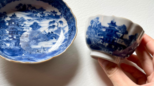 Hand holding a blue and white piece of china