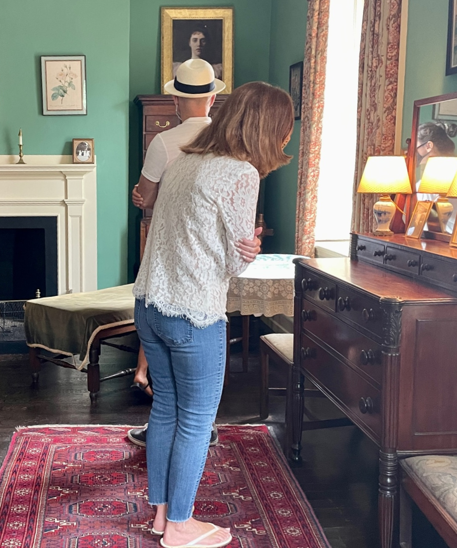 A man and a woman look at objects in Rose's bedroom while on tour